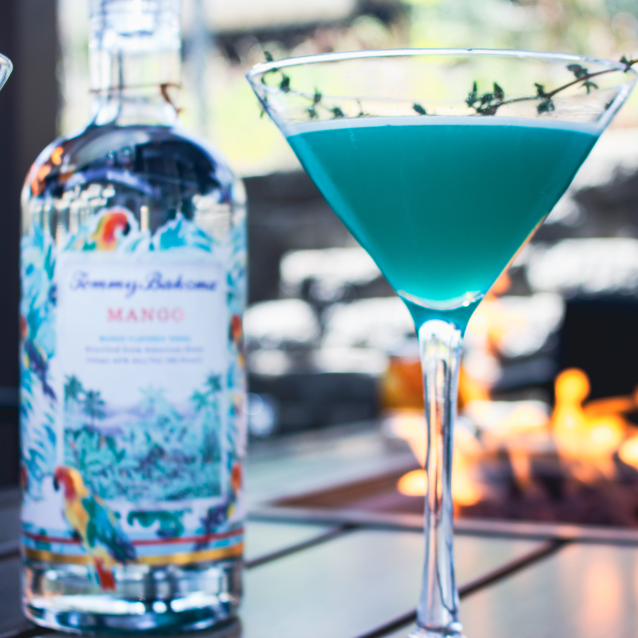 1 oz of Tommy Bahama Spirits Mango Vodka 
1 ½ oz Quantro 
1/2 oz of Blue Curacao 
1 ½ oz Pineapple Juice 
Fresh Lime 
Agave 

Shake it up with 3-4 ice cubes, pour into a martini glass and serve with garnish with a spring of (Island) Thyme.